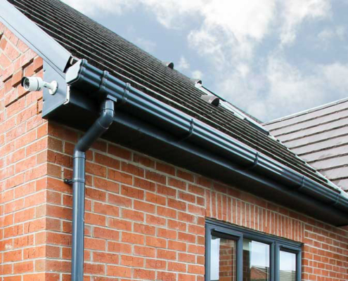 menu-roofline Grey guttering and a fascia board along the roof edge of a brick house in Crawley