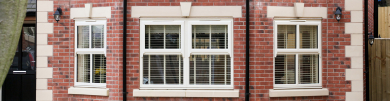 uPVC windows with glazing bars on a brick house, showing how long uPVC windows last